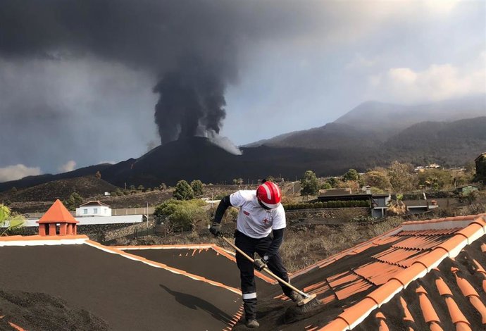 Operario de Cruz Roja limpiando ceniza volcánica