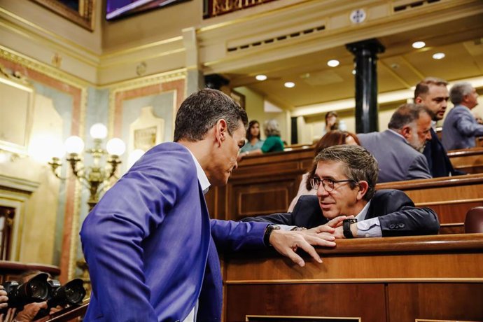 El presidente del Gobierno, Pedro Sánchez (i) y el portavoz del Grupo Parlamentario Socialista en el Congreso de los Diputados, Patxi López (d), conversan durante una sesión plenaria en el Congreso