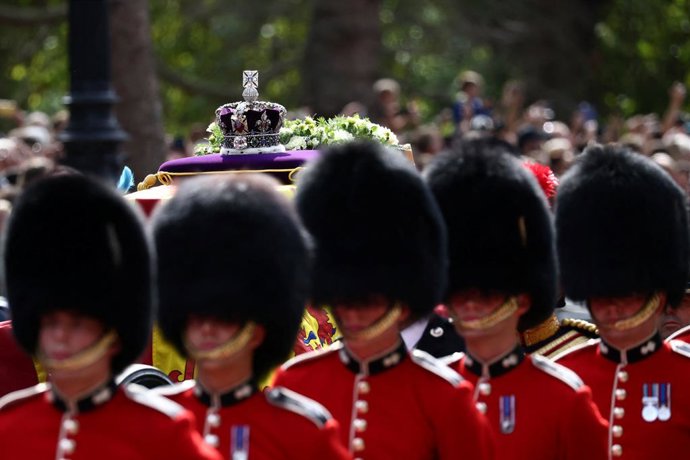 14 September 2022, United Kingdom, London: The coffin of Queen Elizabeth II, draped in the Royal Standard with the Imperial State Crown placed on top, is carried on a horse-drawn gun carriage of the King's Troop Royal Horse Artillery, during the ceremon