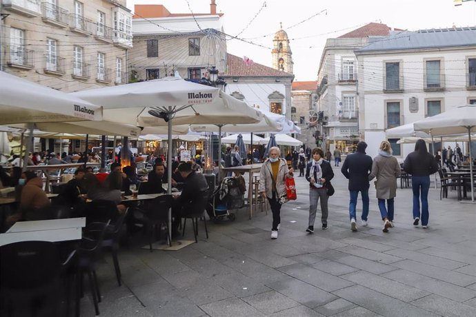 Archivo - Un grupo de personas pasea por las calles tras varios días de lluvia, a 12 de diciembre de 2021, en Vigo