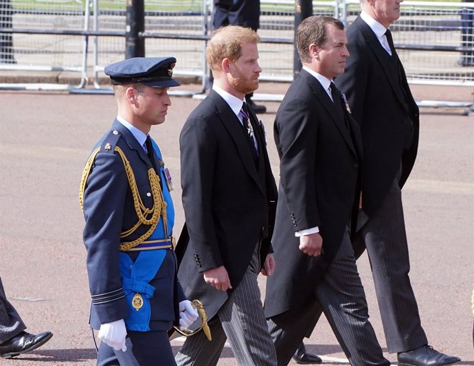 14 September 2022, United Kingdom, London: (L-R)William, the Prince of Wales and Harry, the Duke of Sussex follow the coffin of Queen Elizabeth II, covered with the Royal Standard and the Imperial Crown of State, as it is carried on a horse-drawn carri