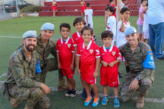 Militares de la BRI X junto a niños libaneses con la equipación del Sevilla FC.