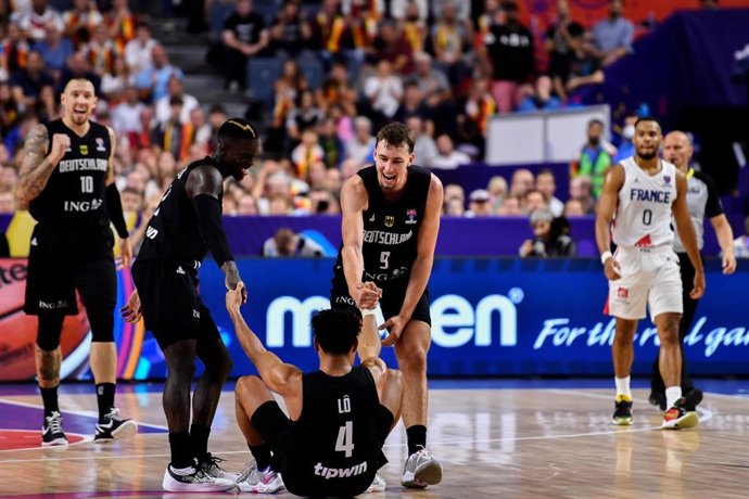 Dennis Schroeder y Franz Wagner ayudan a levantarse a Maodo Lo durante el Alemania-Francia del Eurobasket 2022
