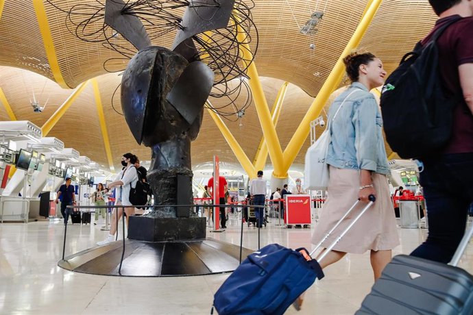 Archivo - Pasajeros con sus maletas en la Terminal 4 del Aeropuerto Adolfo Suárez Madrid Barajas 