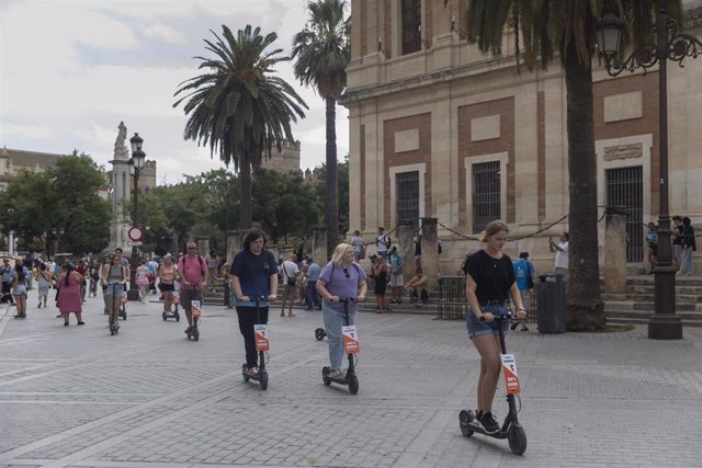 Archivo - Turistas en patinete eléctrico paseando por el entorno de la Catedral. 