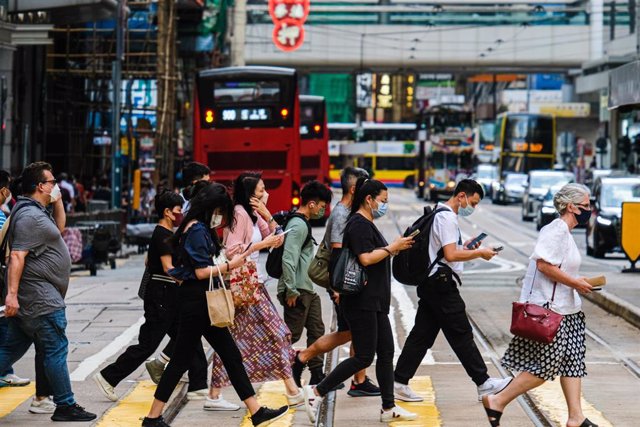 24 August 2022, China, Hong Kong: People cross a street amid strong winds as Hong Kong issued a typhoon warning as tropical storm Ma-on which is making its way toward the city. Photo: Keith Tsuji/ZUMA Press Wire/dpa