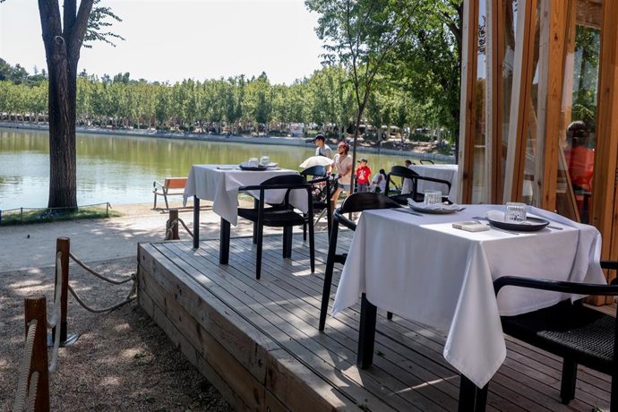 Varias personas disfrutan de la hostelería en las terrazas de las inmediaciones del lago de la Casa de Campo 