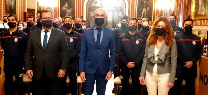 El alcalde de Sevilla, junto a Juan Carlos Cabrera y Clara Macías, con efectivos del Cuerpo de Bomberos de la capital andaluza en un acto en el Ayuntamiento.