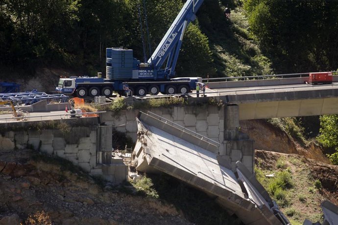 Operarios y grúas trabajan durante el desmontaje del tercer y último vano del viaducto de la A6, a 19 de agosto de 2022, en Vega de Valcarce, León, Castilla y León, (España). 