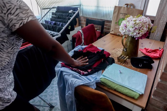 Una empleada de hogar organiza la ropa