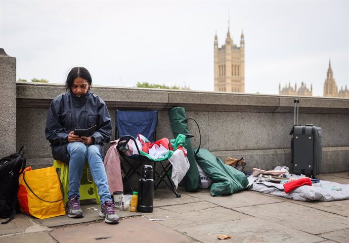 13 September 2022, United Kingdom, London: Vanessa sits opposite the Palace of Westminster, where people begin to queue for the laid out coffin with Queen Elizabeth II in Westminster Hall. on September 14, The coffin of Queen Elizabeth II will be transf