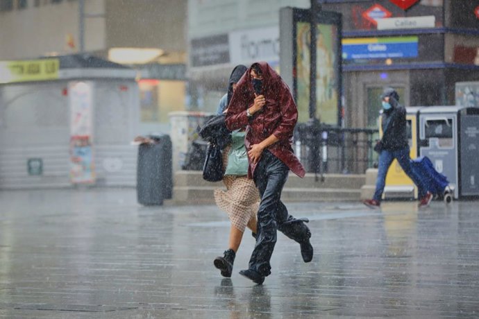 Archivo - Dos personas corren protegidas con su ropa por el centro de la capital en una jornada marcada por las lluvias y la bajada de temperaturas, en Madrid, (España), a 2 de octubre de 2020. Esto se debe a la llegada de la borrasca atlántica Alex que