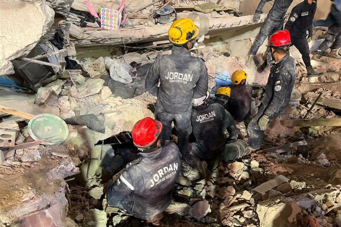 Equipos de Protección Civil de Jordania entre los escombros de un edificio derrumbado en Amán