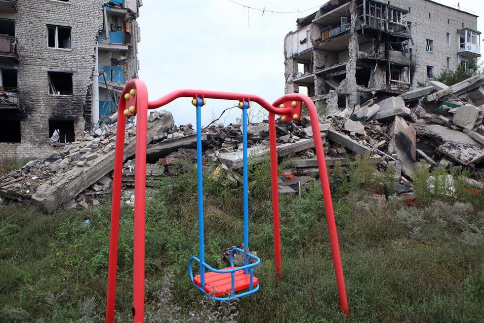 Un columpio frente a un edificio residencial destruido por los bombardeos rusos en la ciudad de Izium, recientemente liberada de la invasión rusa