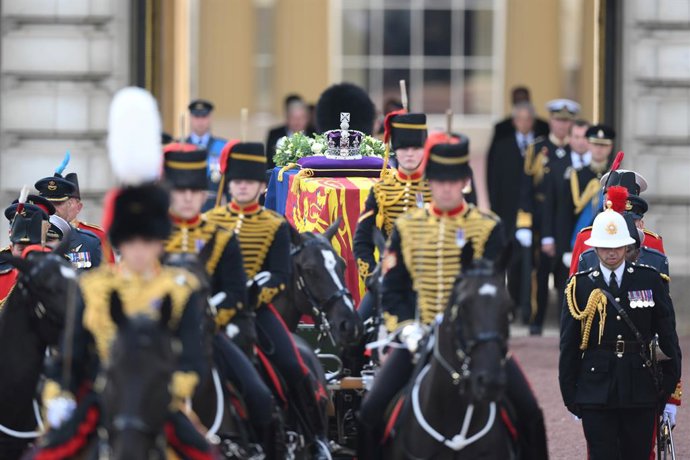 14 September 2022, United Kingdom, London: The coffin of Queen Elizabeth II, draped in the Royal Standard with the Imperial State Crown placed on top, is carried on a horse-drawn gun carriage of the King's Troop Royal Horse Artillery, during the ceremon