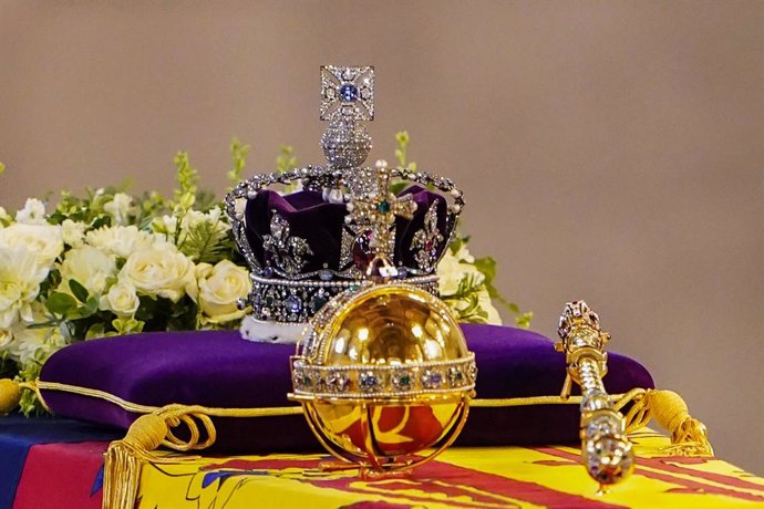18 September 2022, United Kingdom, London: Queen Elizabeth II's coffin, draped with the royal standard, the imperial crown and the sovereign's orb and scepter, lies on the catafalque in Westminster Hall, at the Palace of Westminster ahead of her funeral