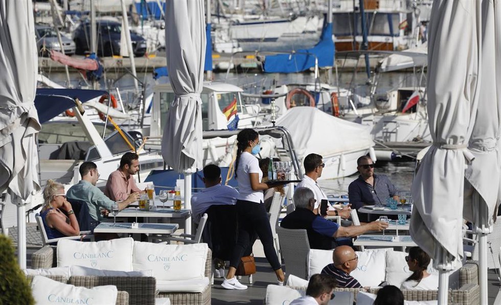 Archivo - Una camarera sirve a clientes en una terraza en Palma.