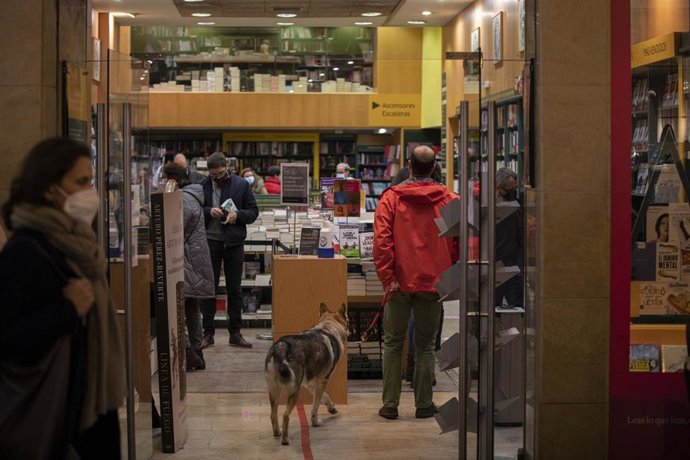 Archivo - Varias personas en una librería