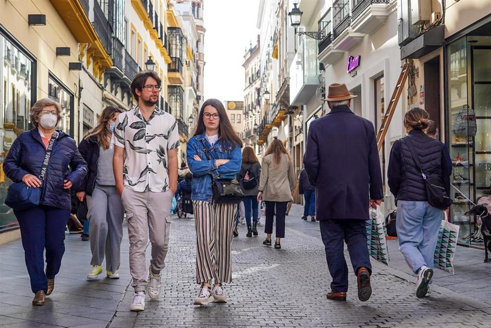 Archivo - Una pareja sin mascarillas y otros ciudadanos con mascarillas por la calle Tetuán, , en el primer día sin la obligación de llevar mascarillas por las calle a 10 de febrero del 2022 en Sevilla (Andalucía) (Foto de archivo).