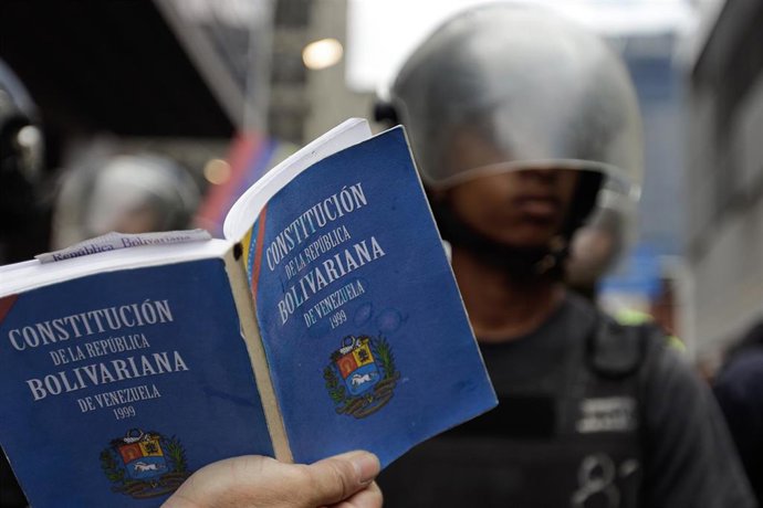Un manifestante con la Constitución de Venezuela en la mano