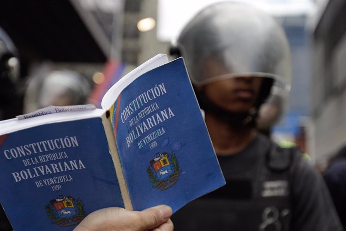 Un manifestante con la Constitución de Venezuela en la mano