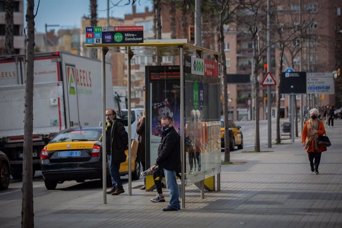 Archivo - Taxis pasan junto a una parada, donde varias personas esperan el autobús, durante la huelga de autobuses en Mitre Ganduxer, a 17 de febrero de 2022, en Barcelona, Cataluña, (España). Los sindicatos CCOO, UGT, ACTUB, SIT, CGT y ACAT han convoca