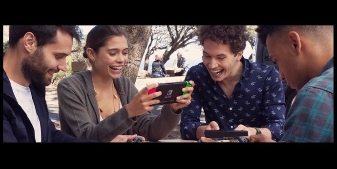 Cuatro personas jugando con una consola Nintendo Switch