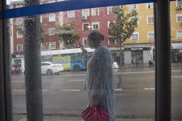Una mujer con un paraguas pasa junto a una ventana, a 15 de septiembre de 2022, en el distrito de Carabanchel, en Madrid (España). Las precipitaciones producidas por la borrasca ‘Danielle’ en la Comunidad de Madrid se van a intensificar en el día de hoy c