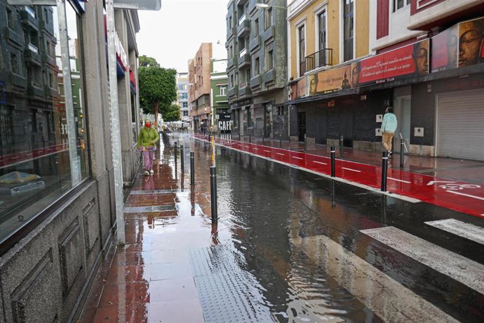 Archivo - Una mujer camina bajo la lluvia en Las Palmas de Gran Canaria, en Canarias (España), a 4 de febrero de 2021. Canarias recibió este miércoles una profunda vaguada atlántica que provocará un aumento considerable de la inestabilidad atmosférica d