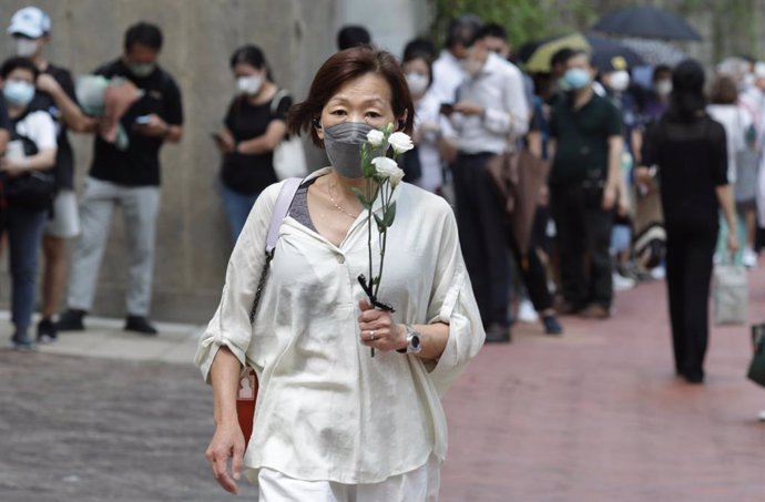 19 September 2022, China, Hong Kong: A woman brings flowers to the British Consulate General in Hong Kong to pay last respect to the late Queen Elizabeth II. Photo: Liau Chung-Ren/ZUMA Press Wire/dpa