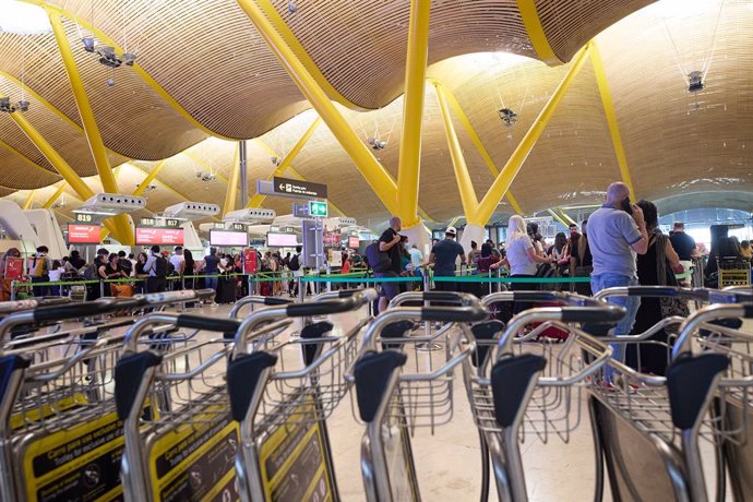 Archivo - Viajeros esperan con sus enseres en el aeropuerto Adolfo Suárez Madrid-Barajas, a 12 de agosto de 2022, en Madrid (España).