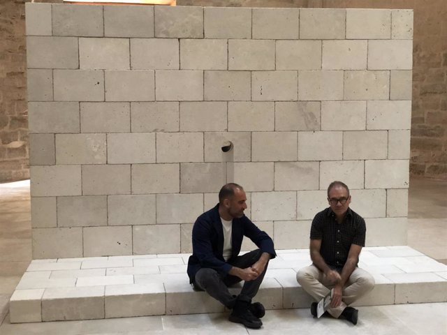 El director del Museo Patio Herreriano, Javier Hontoria, sentado junto al artista Alberto Peral (derecha) con la pieza central de 'Dar la vuelta' a sus espaldas.