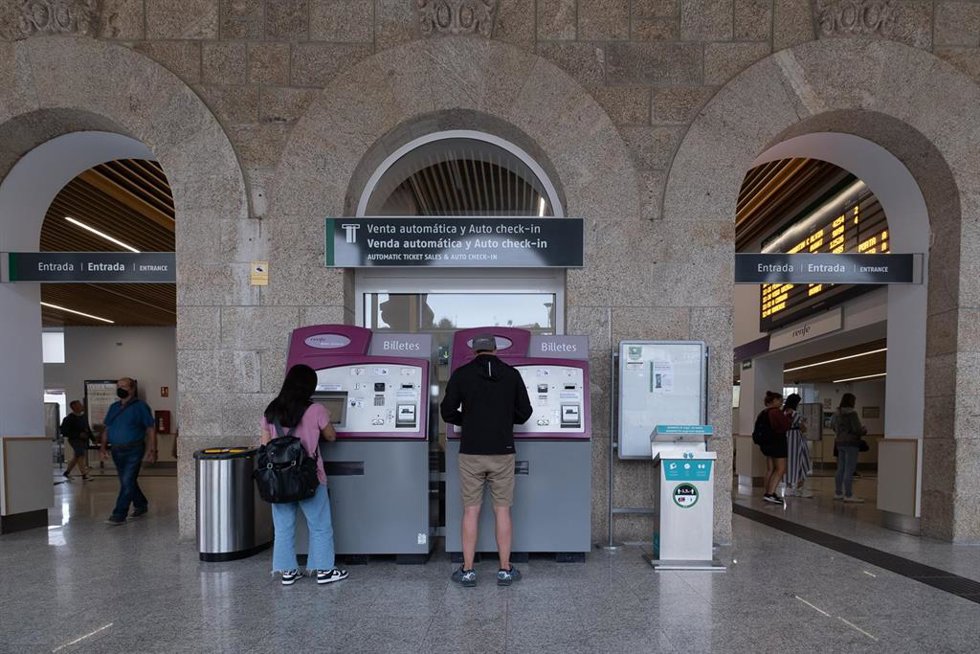 Dos personas compran billetes en los cajeros de venta automática en la estación de trenes, a 24 de agosto de 2022, en Santiago de Compostela, A Coruña, Galicia, (España). Los usuarios de Renfe en Galicia pueden adquirir desde hoy los abonos gratuitos.