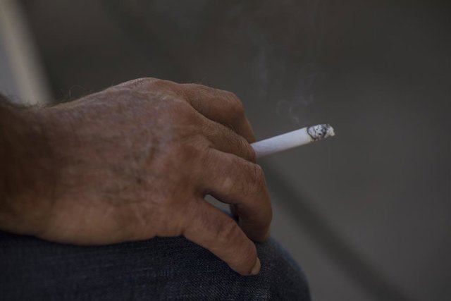 Archivo - Una persona fuma a la terrassa d'un bar.