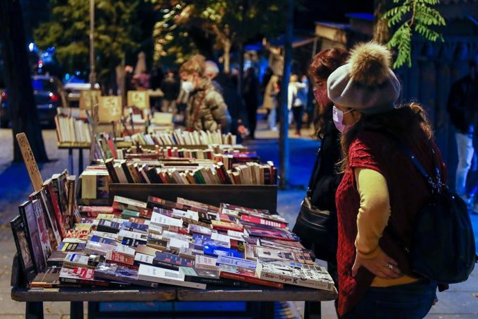 Archivo - Varias personas se acercan a los puestos y casetas de libros en la Cuesta de Moyano
