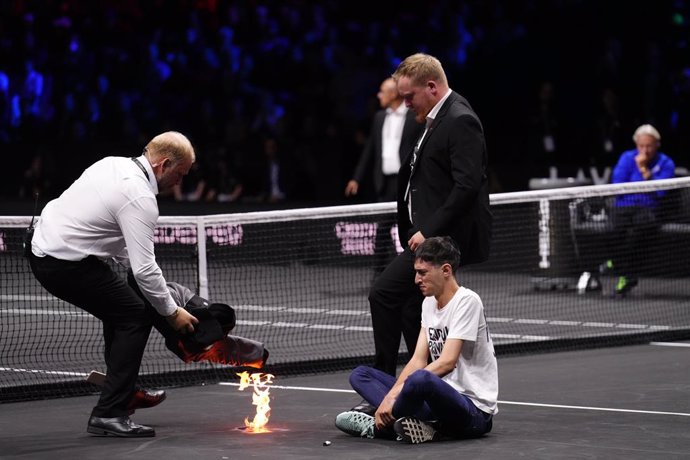 23 September 2022, United Kingdom, London: A protester lights a fire during the Team World's Diego Schwartzman from Argentina match against Team Europe's Stefanos Tsitsipas from Greece on day one of the Laver Cup at the O2 Arena. Photo: John Walton/PA W