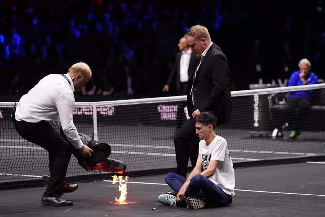 23 September 2022, United Kingdom, London: A protester lights a fire during the Team World's Diego Schwartzman from Argentina match against Team Europe's Stefanos Tsitsipas from Greece on day one of the Laver Cup at the O2 Arena. Photo: John Walton/PA Wir