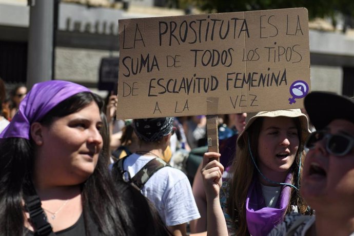 Archivo - Una persona sujeta una pancarta en la que se lee: 'La prostituta es la suma de todos los tipos de esclavitud femenina a la vez'