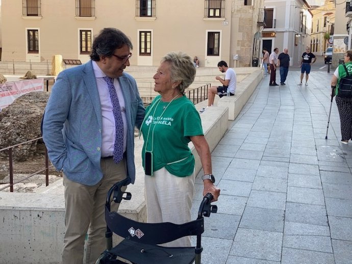 El consejero de Sanidad, José María Vergeles, saluda a la presidenta de ELA Extremadura, Lola Dorado, en el 9 Encuentro de la Plantaforma del Voluntariado de Mérida.