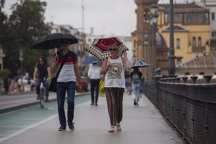 Varias personas caminan bajo sus paraguas el día en que han puesto en aviso amarillo a la Comunidad de Andalucía por tormentas y lluvias. A 13 de septiembre de 2022, en Sevilla (Andalucía, España). 