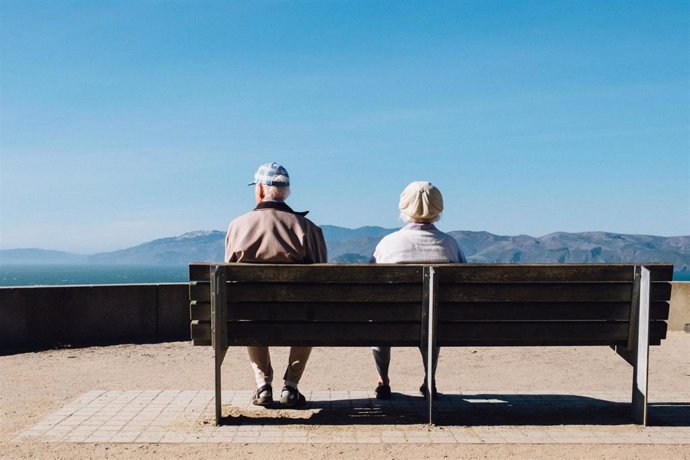 Dos personas de avanzada edad miran el horizonte.