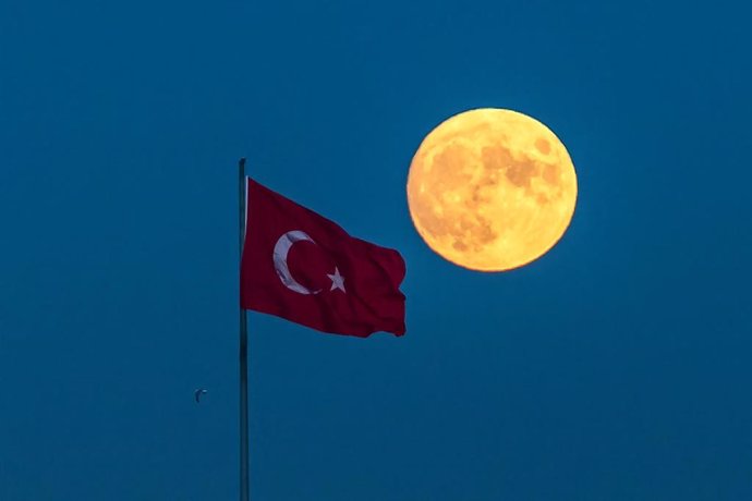 Luna llena junto a una bandera turca en Estambul