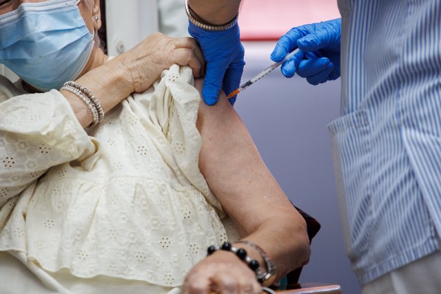 Un enfermero vacuna de la dosis Moderna a una anciana durante el inicio de la administración de la cuarta dosis de la vacuna frente al COVID-19 a los usuarios y trabajadores sociosanitarios de residencias, en la Residencia pública de Mayores de Valleca