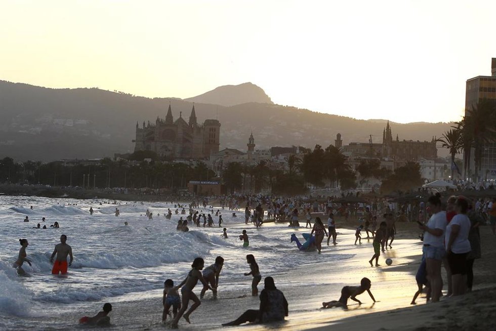 Archivo - Centenares de personas se bañan en una playa en Palma. 