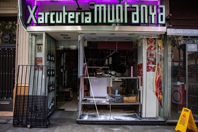 Desperfectos y cristales rotos en un escaparate de una charcutería causados por los altercados en las Fiestas de la Mercé