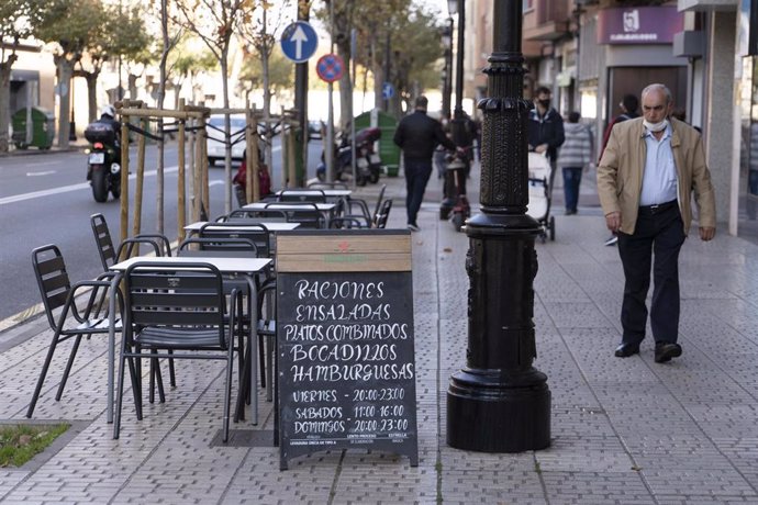 Archivo - Un hombre camina frente a la terraza de un bar en Logroño