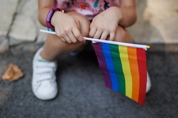 Archivo - Una niña sostiene la bandera del arcoiris minutos antes del inicio de una manifestación por el Orgullo LGTBIQ+.