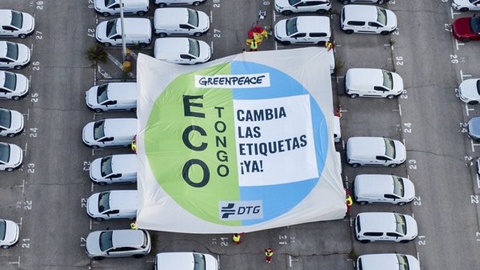 Greenpeace despliega una pancarta con forma de etiqueta de la DGT sobre varios vehículos para denunciar el 'ECO tongo'