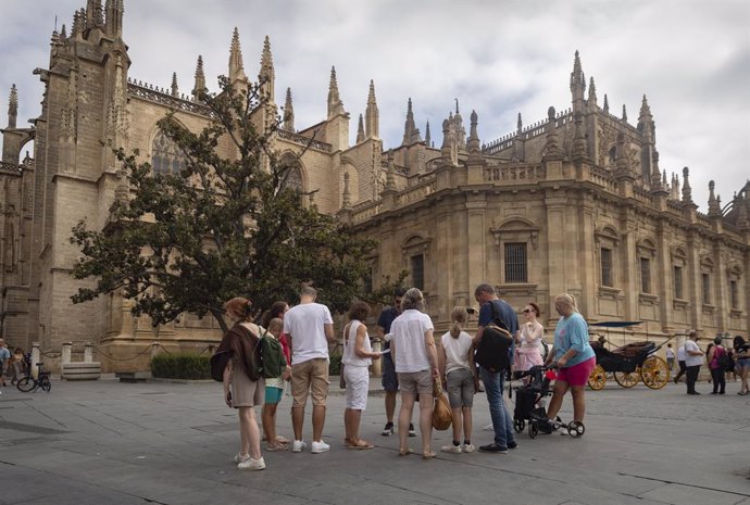 Archivo - Un grupo de turistas ante la fachada de la Catedral. A 11 de agosto de 2022, en Sevilla (Andalucía, España).