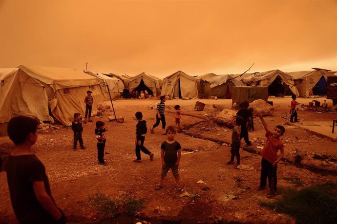 Archivo - Niños jugando durante una tormenta de arena en un campamento de desplazados en la provincia de Idlib, en el noroeste de Siria